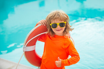 Happy kids boy play in swim guard or lifeguard in the sea. Funny child boy with lifebuoy show...
