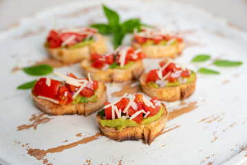 Bruschetta Sandwich served as an appetizer with tomato, avocado, onion and balsamic glaze