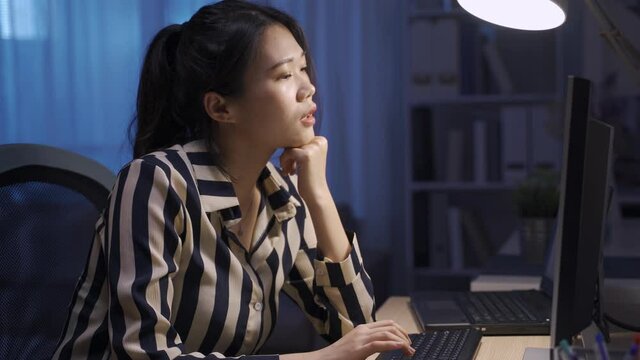 chinese businesswoman propping head in front of pc screen is suffering nuchal rigidity.