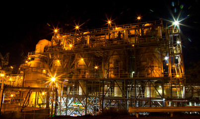 
Mount Isa Mine Processing Plant. An industrial sulphuric acid plant containing 3 stage catalytic conversion, gas cleaning and drying towers, Copper Smelting. Illuminated night shot of acid plant.
