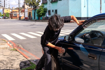 man with face mask cleaning his car