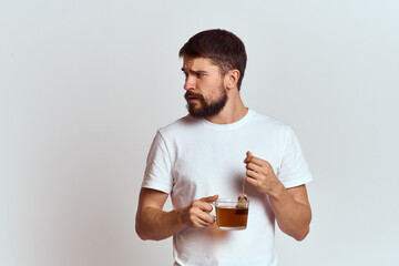 man with a cup of tea in a bag on a light background Hot drink cropped view model