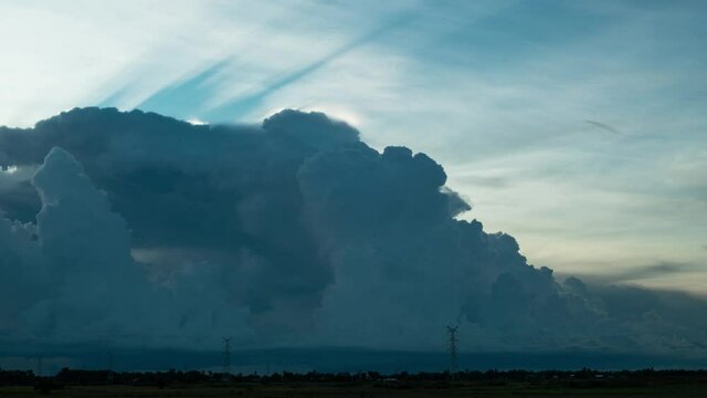 Light rays behind a forming cumulonimbus as the cloud hits the stratosphere
