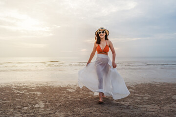 Fototapeta na wymiar cheerful woman in bikini walking on sea beach