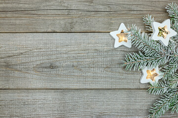 glowing star garland lights with christmas tree branch on gray natural wooden background