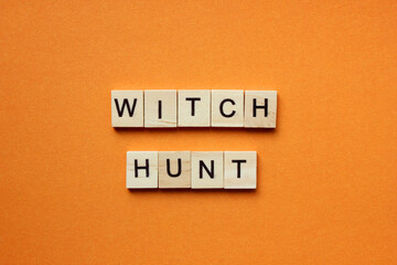 Words Witch Hunt. Wooden blocks with an inscription on an orange background. Bulletin board. The concept of the holiday is Halloween. The view from the top. Copy space