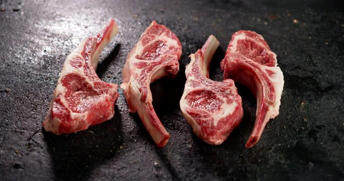Pieces of raw rack of lamb on the table slowly rotate. 