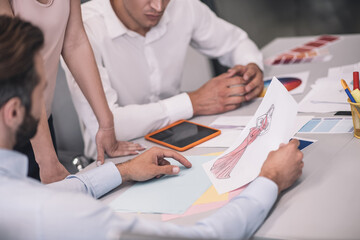 Close-up of male hands showing dress sketch