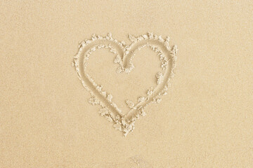 Fototapeta na wymiar Draw single hearts in the sand on the beach