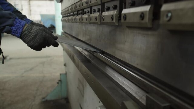Factory worker operates with a CNC guillotine shears
