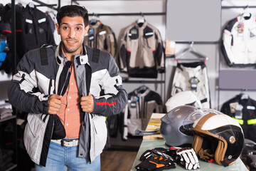 Adult man is trying up new jacket for motorbike in the store