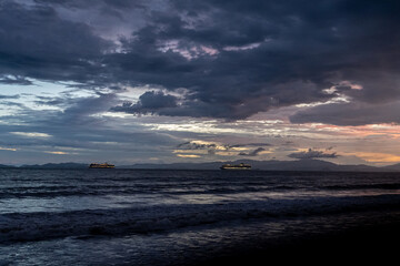 Beautiful aerial view of the majestic sunset with palm trees, ocean and cruise ships in Costa Rica 