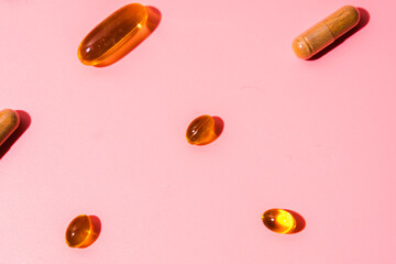Top view of pills on pink pink background with harsh shadows. Trendy flatlay of preventive medicine