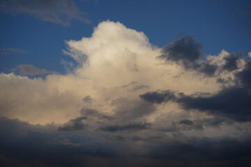 Blue sky with clouds. Dramatic sky. An impending thunderstorm. Thunderclouds at sunset. Dark clouds in the sunlight. Cloudoscape.