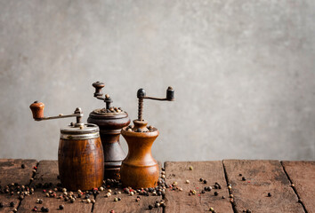 Various kind of vintage pepper mills on wooden table