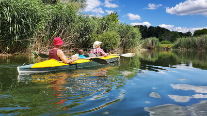 family kayaking on the river