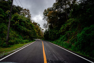 Countryside road passing through the serene lush greenery and foliage tropical rain forest mountain landscape on the Doi Phuka Mountain reserved national park the northern Thailand