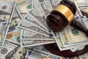 Many hundred dollar bills with judge gavel