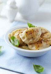 Dumplings with potato and cottage cheese stuffing (pierogi). Traditional Polish Christmas Dinner. Bright background. 