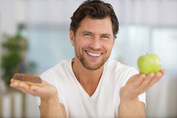 man with donut and apple in his hands