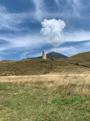 Old tower in mountains, sky background