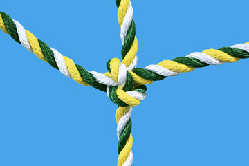 Multicolored rope knot isolated on a blue background. Close-up.