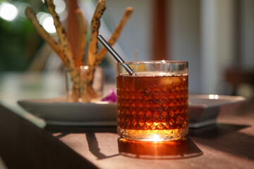 Salty sticks and iced tea served on the restaurant table.