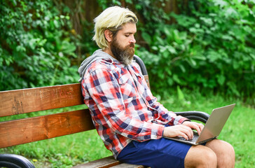 Fototapeta premium Online shopping. Working online. Hipster inspired work in park. Fresh air. Mobile internet. You can work anywhere. Agile business. Bearded guy sit on bench in park nature background. Work and relax
