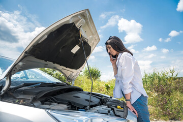 Young woman waiting for help near damaged car.