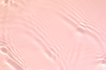 Fototapeta premium Closeup of pink transparent clear calm water surface texture with splashes and bubbles. Trendy abstract summer nature background. Coral colored waves in sunlight.