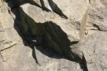 強い日光を浴びて濃い影が出来ている岩場