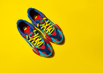 Multicolor sport shoes on yellow background with shadows - 377833394