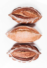 Various types of Bakery bread - fresh rustic crusty loaves of bread and baguette on white background.  (top view, flat lay).