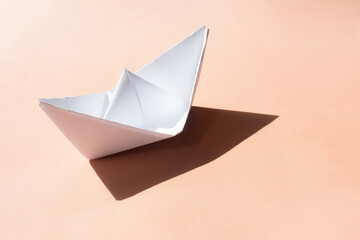 paper ship with shadow on sand background