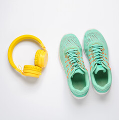 Sportive shoes and headphones on white background