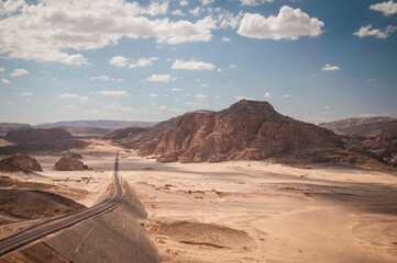 Desert landscape with blue sky and sun and road