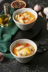 Bowls of tasty rice soup on dark background