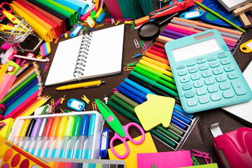 School supplies. Composition of colorful school accessories isolated on the brown table. Top view.