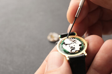 Clockmaker repairing broken watch at table, closeup - obrazy, fototapety, plakaty