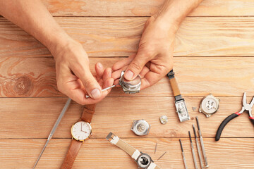 Clockmaker repairing broken watch at table