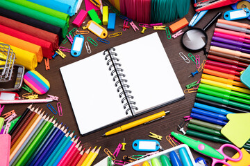 School supplies. Composition of colorful school accessories isolated on the brown table. Top view.