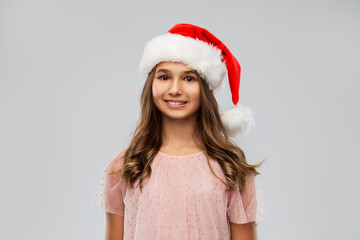 christmas, holidays and people concept - happy smiling teenage girl in santa helper hat over grey background