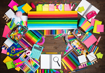 School supplies. Composition of colorful school accessories isolated on the brown table. Top view.