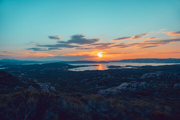 Beautiful sunset over the La Maddalena archipelagos, in Sardinia, Italy, from the natural reserve of Caprera Island. Sunset over water, sun reflections, unique sky.