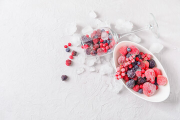 Tasty frozen berries and ice on table