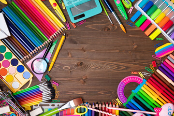 School supplies. Composition of colorful school accessories isolated on the brown table. Top view.