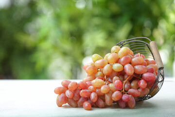 Basket with ripe grapes on table outdoors