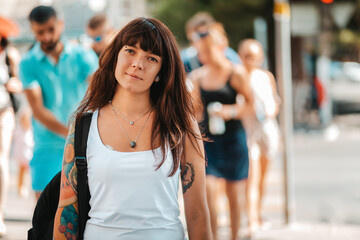 Portrait of a smiling woman crosses the road. In the background, people are blurred. The concept of socialization and the rules of the road