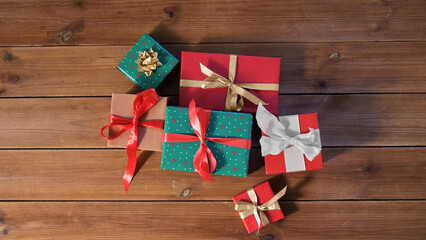 Fototapeta na wymiar christmas, holidays and celebration concept - gift boxes on wooden boards from top