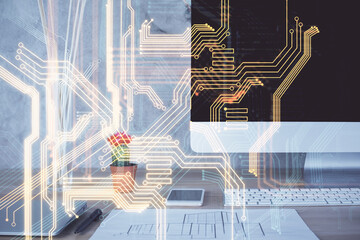Computer on desktop in office with technology theme hologram. Double exposure. Tech concept.